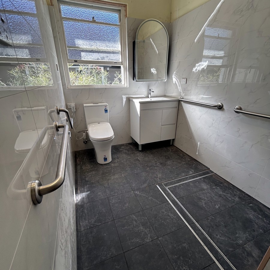 Accessible bathroom with grab rails, level-entry shower and toilet