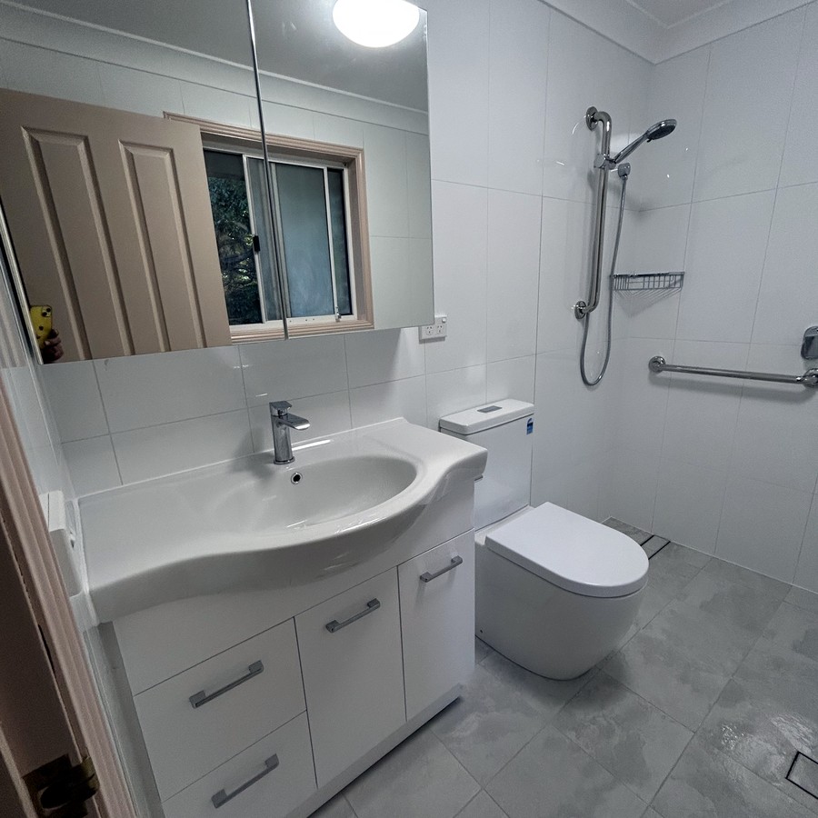 Accessible bathroom with vanity, grab rails and walk-in shower