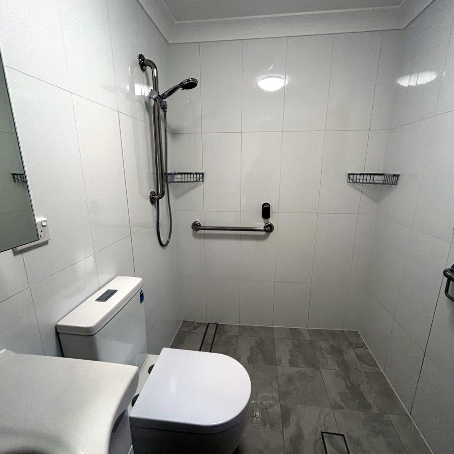Accessible bathroom with grab rails and a walk-in shower