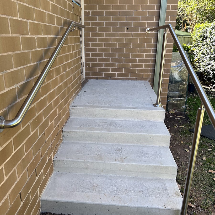 Concrete entry steps with a stainless steel handrail