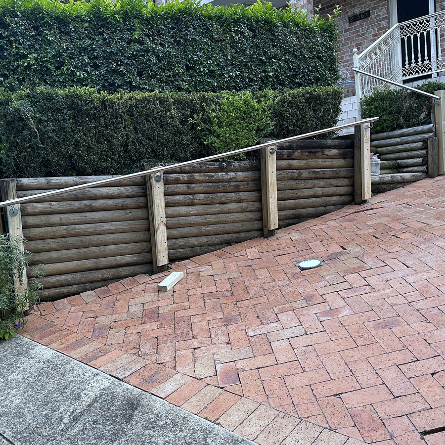 Stainless steel handrail running along a pathway to a home