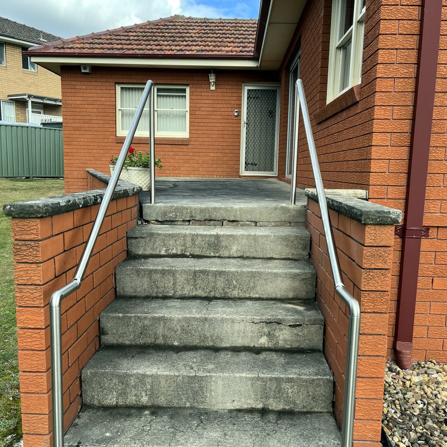 Stainless steel handrail on concrete entry steps