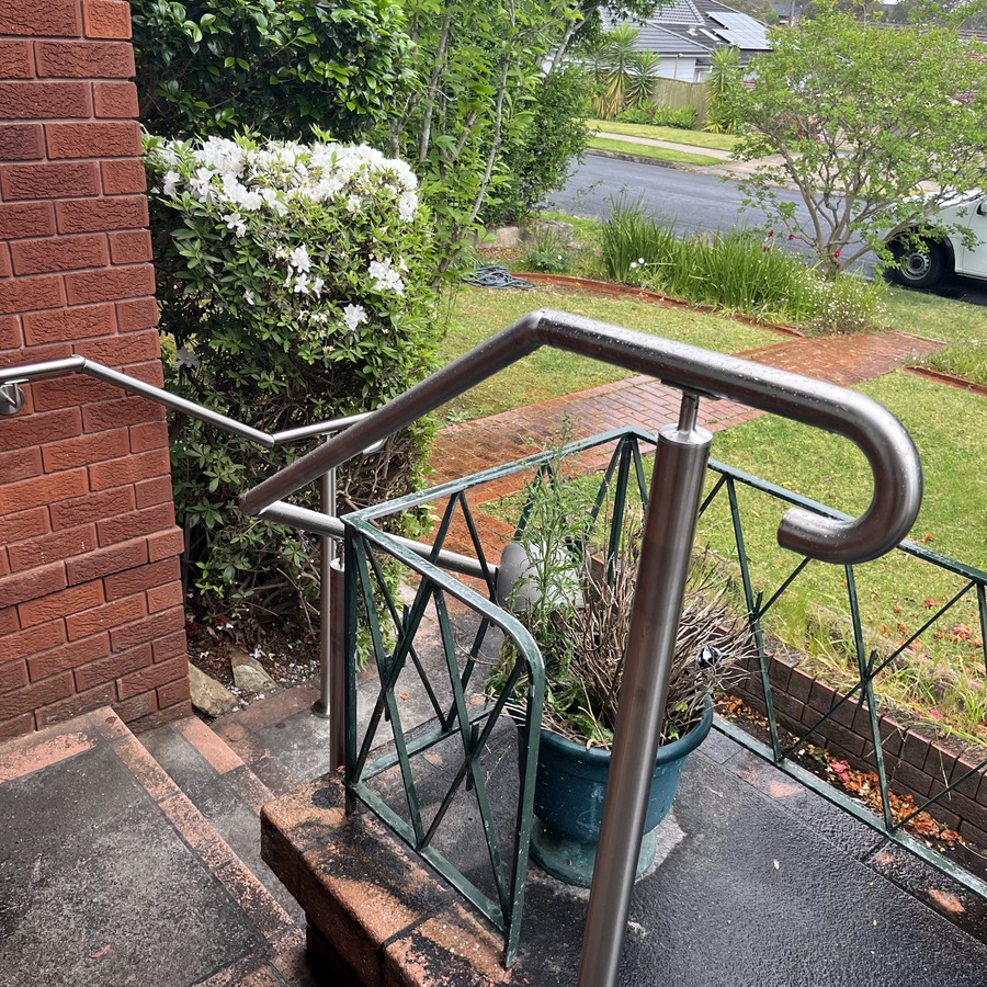 Stainless steel handrail on brick steps with a decorative balustrade