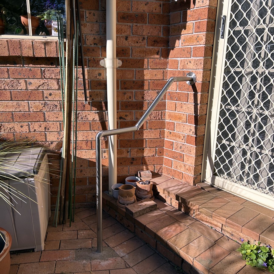 Stainless steel handrail at a brick home entrance