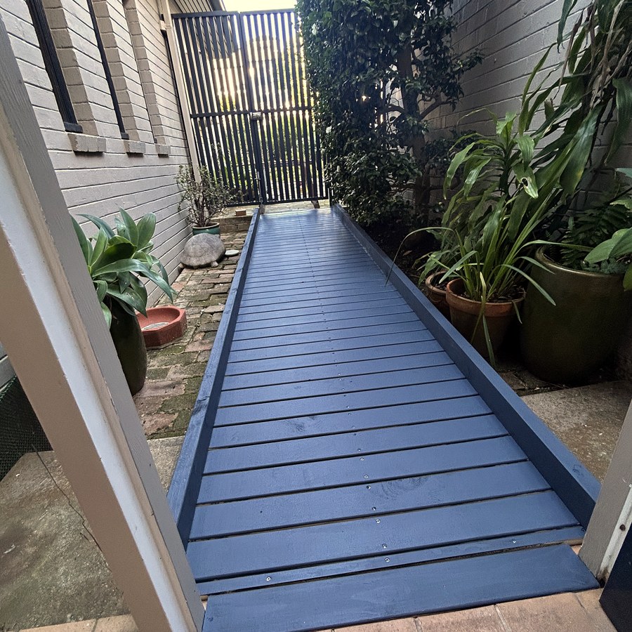 Long timber walkway access ramp running alongside a house