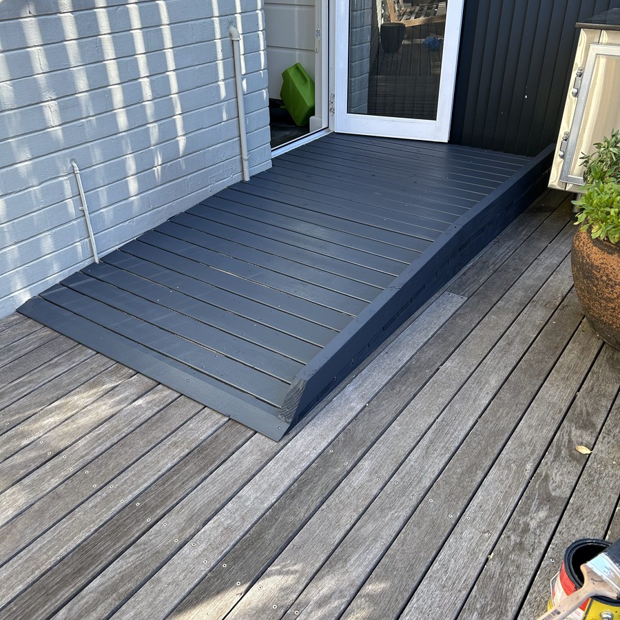 Dark threshold ramp over a step on a timber deck