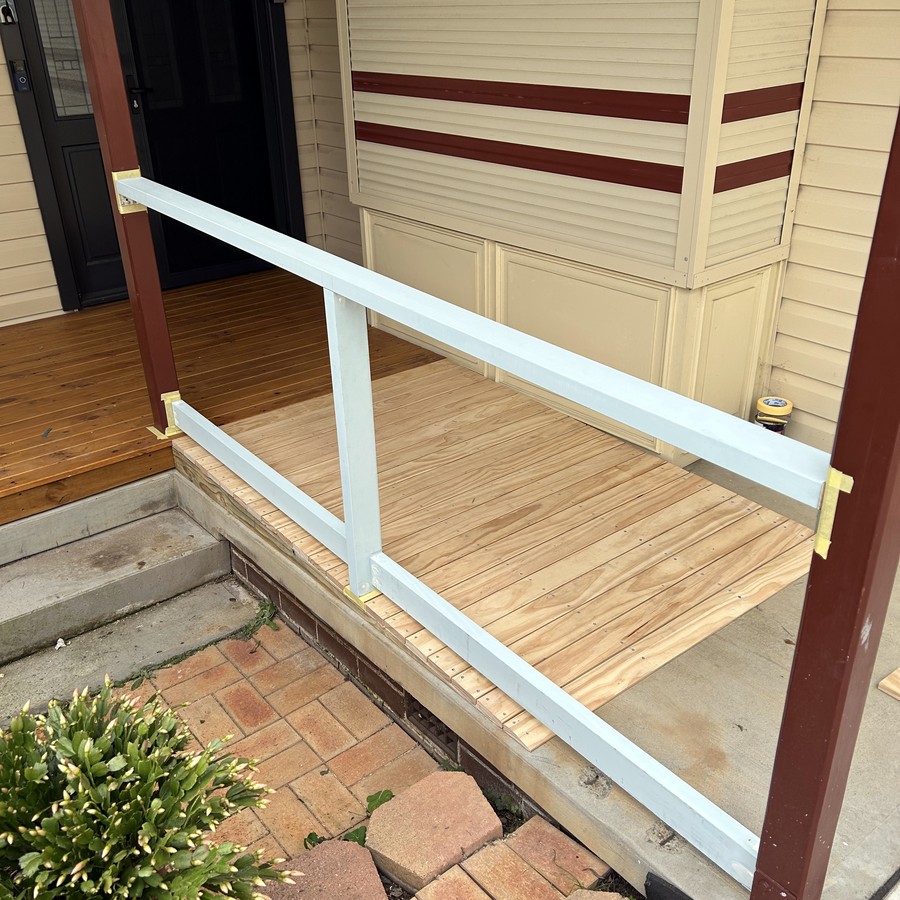 Timber access ramp with a handrail at a doorway